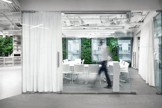 The+conference+room%2c+which+is+one+of+the+few+enclosed+spaces+in+the+floor+plan%2c+features+glass+walls+that+can+be+closed+off+by+opaque+curtains.
