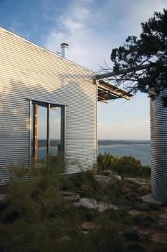 In keeping with the project's simple, elemental aesthetic, a halved steel pipe creates a gutter connecting the roof to the rainwater tank.