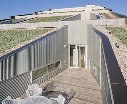 A staggered-truss structural system enables a sloping green roof.