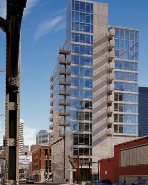 Varied building volumes echo the diverse character of the surrounding neighborhood. Inside (below), rough exposed concrete pillars complement refined hardwood floors.