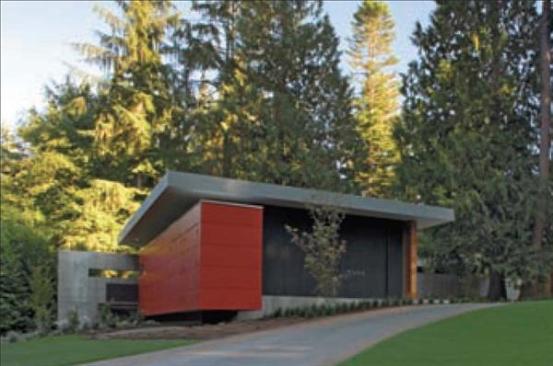 A red fiber cement clad storage box defines an edge of the music studio garage and reappears on the house. 