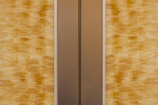 CabForms Series 2000-N Elevator Interior with upper inset panels in ViviStone Honey Onyx, Pearlex finish; stiles and rails in Stainless Steel, Seastone finish at the Woolworth Building, Eugene, Oregon