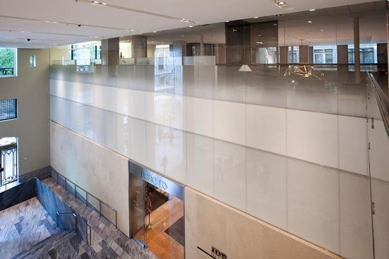 Railing infill in ViviGraphix Gradiance glass with Dot Mini Fade interlayer and Standard finish; wall in ViviChrome Chromis glass, Reflect configuration with White interlayer and Standard finish; wall accent in ViviChrome Chromis glass, View configuration with White interlayer and Standard finish at HSBC Bank, New York, New York