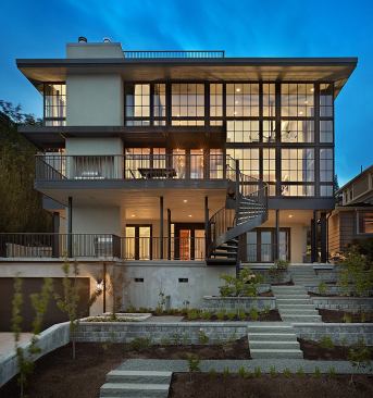 Prospect House-Seattle, WA Prospect House is the result of celebrating a stunning Seattle panorama while accommodating a modest budget and a family with two young children. The house honors the owner's desire for a domestic refuge while maximizing the experience of its location. The project began with the domestic and the planting of two gabled, bearing-wall "houses" deep into the hillside. These contain rooms requiring enclosure, and they give the house the conventional street fa&ccedil;ade that the neighborhood deserves. The steel-framed "glass box" occupies the view fa&ccedil;ade and sews the houses together. These simple parts, simply combined, create complex social and spatial relationships within the house. The budget required basic construction usingoff-the-shelf parts. The greatest technical effort went into the design of the two-story window wall: residential wood windows assembled as a true curtain wall. 
Architect: Janof/Hald Architecture