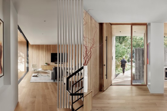 Left: An alternative view of the primary living room; Right: Rift-sawn white oak clads the entryway of the main house and continues into the living area.