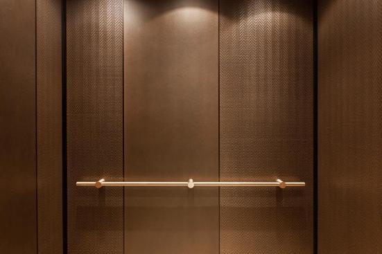 LEVELe-105 Elevator Interior with main panels in Bonded Bronze with Dark Patina and Mazatl?n pattern; accent panels in Bonded Bronze with Dark Patina and custom pattern; Compass handrail in Satin Bronze at Residences at the InterContinental, Boston, Massachusetts