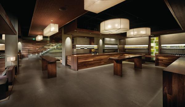 The two main horseshoe-shaped tasting bars were outfitted with custom wine display cases and signage that identifies each of the eight wineries that are in residence. Soffits help to define spaces in the open-plan space by defining tasting zones, circulation zones, and lounges. LIGHT FIXTURE FABRIC SHADE - Knoll Textiles - Imago Progeny drapery fabric in Blonde - knoll.com - PAINT - Kelly-Moore - Interior latex paint in black - kellymoore.com - WALL WASHER LIGHT FIXTURES - Danalite - Fluorescent T8 downlight wall washers - danalight.dk