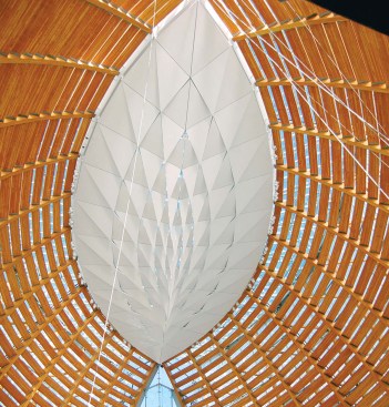 Above the sanctuary hovers an oculus with a scrim of faceted acoustical panels. The panels help absorb sound in the cavernous interior and filter daylight from the skylight above.