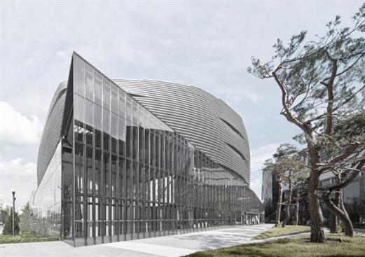 The+glazed+west+corner+of+the+building+protrudes+into+the+surrounding+plaza.