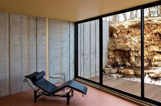 Concrete retaining walls rise out of existing rock outcroppings, strengthening the buildings connection to the site