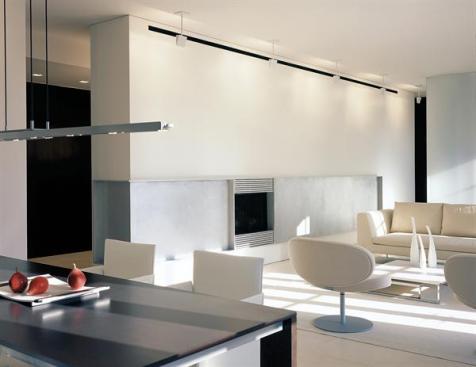 A limited palette of seamless materials give this apartment an orderly coherence. The fireplace wall is fitted with an 8-foot aluminum panel that conceals a TV.
