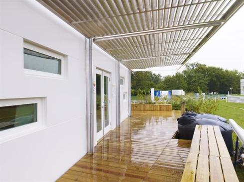 Hinged, aluminum, louvered panels provide privacy and full-perimeter shading, and were designed as a prototype to protect against hurricane-force winds.