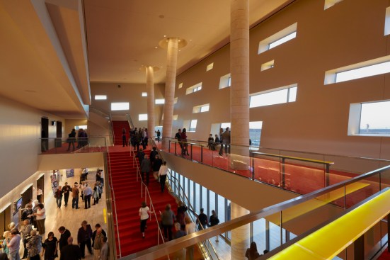 Inside the lobby, thick sculptural walls suggest spaces carved from solid rock