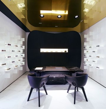 Clients are surrounded by different eyeglass options while they sit down and try on different pairs of frames. 4000K LED adjustable downlights provide light to the desktop below.