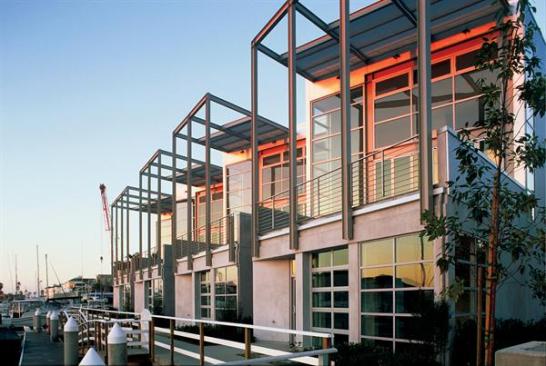 Metal siding, steel frames, and exposed rooftop mechanical equipment add a commercial edge to the live/work buildings of Cannery Lofts.