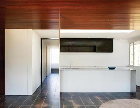 Stainless steel columns so slender that they are practically two dimensional mark the path of the partition that isolated the original kitchen from the living and dining areas.