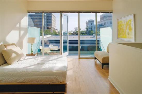 A bedroom and balcony overlook the street scene.