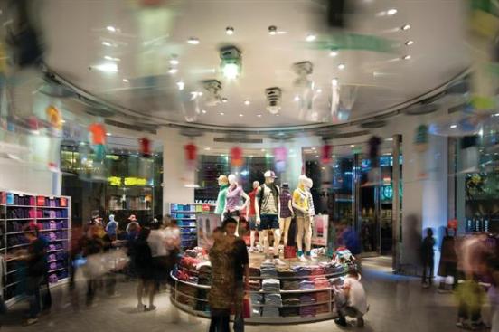 Uniqlo is known for making clothing in a whole spectrum of colors, so the inventory in the store actually becomes part of the design. Here, in the bull-nosed portion of the ground-floor retail space, shoppers are enticed by mannequins in capsules that rotate overhead on a track mounted on the ceiling. Throughout the store, mannequins showcasing the brand's wares are mounted near ceiling height?on ledges ringing the structural columns or on top of shelving?so that customers can see the clothes even from inside a throng of other shoppers.