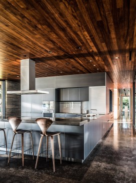 Inside, ceiling panels from East Teak Fine Hardwoods—the source for all of the wood in the project—run above polished concrete floors.