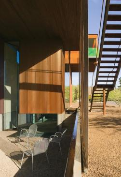 Strategic shading, an industrial mesh screen, and a surrounding water element help passively cool the studio courtyard.