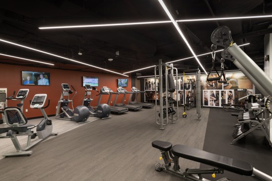 On both the floor and ceiling, a series of angles helps to energize and visually enlarge the fitness area.