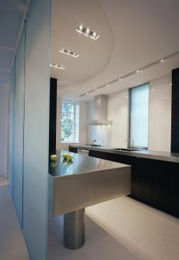 In the kitchen, two sliding laminated glass panels hide doublehung windows.