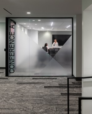 A double layer of frosted film on the conference room windows repeats the grid pattern carried throughout.