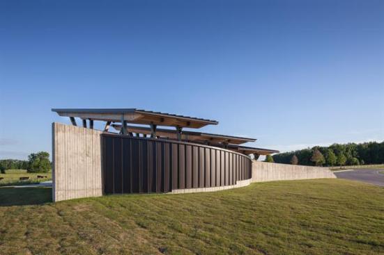 The+board-formed+concrete+bearing+wall+shields+also+serves+as+a+barrier+from+the+nearby+driveway.