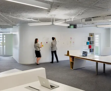 Three-pronged light fixtures mark the area over the Radar Desk; the walls are lined with white board paint to allow for idea generation.