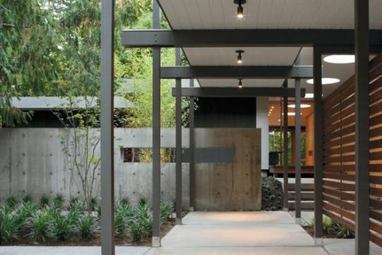 A concrete wall screens the bedroom wing from view of the driveway.