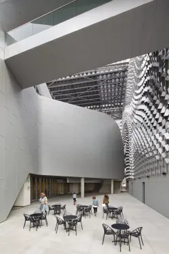 One of the most striking features of Morphosis’s design is the eight-story sunscreen that shades the building’s two internal façades. The firm used computational scripting to determine the final geometry. Over the better part of a year, in-house designer/programmers input the parameters that created the undulating and dynamic surface. The scripting program responded to inputs such as the curvature of the classroom building and the location of the elm tree in the fifth-floor courtyard.
