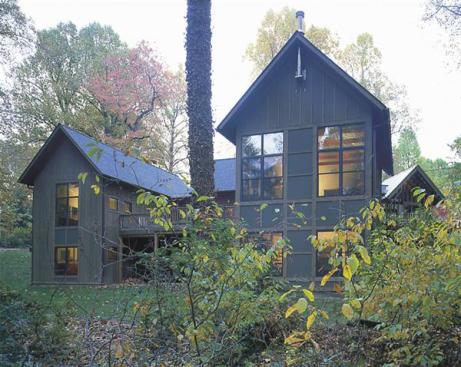Architect Wayne Good chose log slab cladding to recall the neighborhoods summer cabin roots. Windows wrapthe living rooms gable end to capture sylvan views.