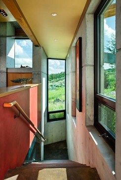 Interior, vertical, looking down stairway to lower level with views out to mountains, Landes-Oatey residence, Jackson, Wyoming; Ward + Blake Architects