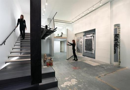 A folded wood wall helps define the gallery space.