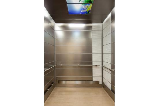 LEVELe-103 Elevator Interior with main panels in Stainless Steel with Sandstone finish; accent panels in Bonded Quartz, White with Kalahari pattern; Compass handrails in Satin Stainless Steel at Florida Hospital Celebration Health, Celebration, Florida