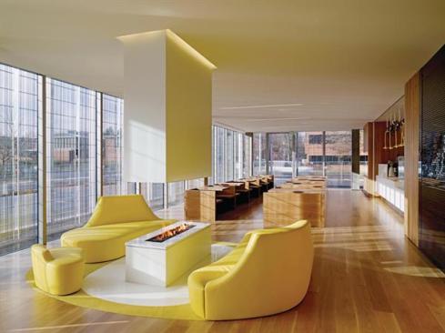 The face features a four-sided gas fireplace surrounded by a leather lounge seat suggesting the University of Oregon's "O."