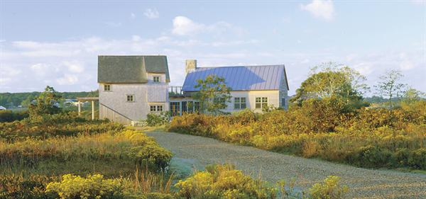 The combination of different forms and roof materials (cedar shingles and standing-seam metal) gives the two-part guesthouse a look of having evolved over time.