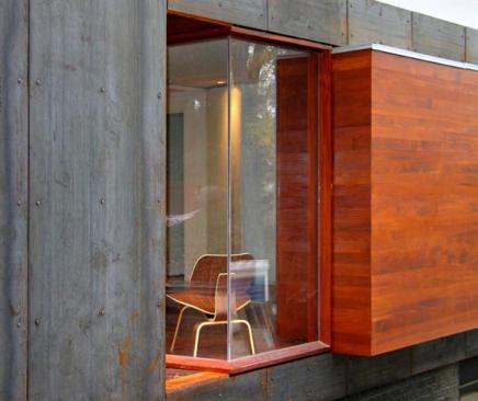 Clear-finished cedar siding mark the modest bump-outs of the existing floor plan. Cor-Ten panels wrap the existing exterior walls.