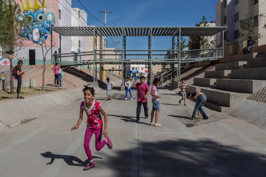 Located in a former sewage canal near a multifamily complex in Zacatecas, Mexico, this playground features a bridge canopy that extends over an esplanade.