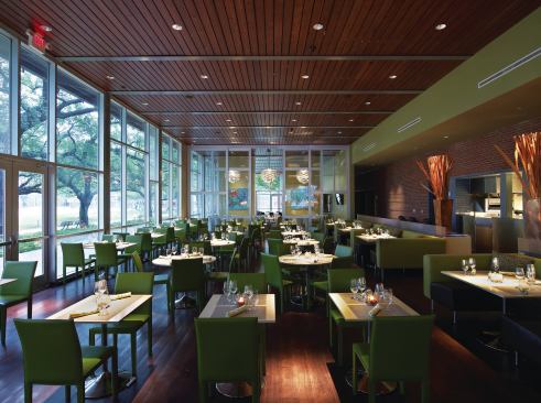 The main dining room uses a wood floor and ceiling, similar to the second-floor dining space. Expanses of glazing allow diners to enjoy views of the new downtown park while feasting on American fare ranging from salad and sandwiches to local seafood. Beyond the interior glass wall are two smaller dining spaces (denoted by the Louis Poulsen artichoke lighting fixtures) that can be closed off for private parties. The interiors were designed by a team from Schiller Del Grande Restaurant Group, the company that runs The Grove, in an effort to give the restaurant the same feel as the company’s other properties.
