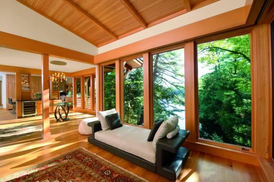 
  Nestled
  away adjacent to a lake, this lakeside residence is an example of fixed
  rusticity. The bright oak finish glows in comparison to the lush green forest
  beyond, creating a certain brightness throughout the home.