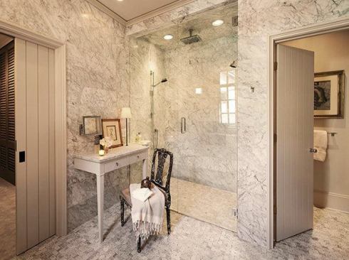 The larger, more open shower has become the focal point of the master bathroom. It boasts a thermostatic control valve, a normal shower head, a rain head, and a hand-held sprayer along with a remote sound system.