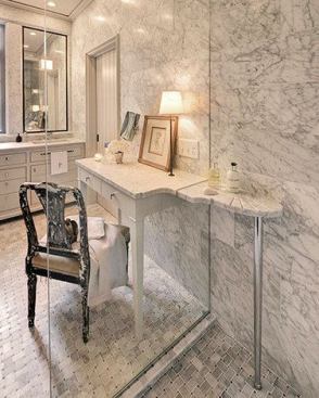 The dressing table counter slices through the shower glass to become a shelf with a scalloped soap dish and grooved drains along the edge.