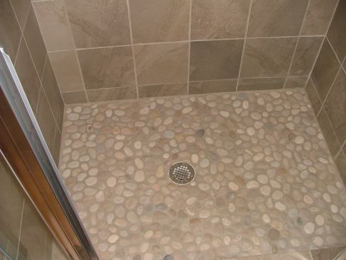 A river rock shower floor is one of many unique details of the Eco Building Group house.