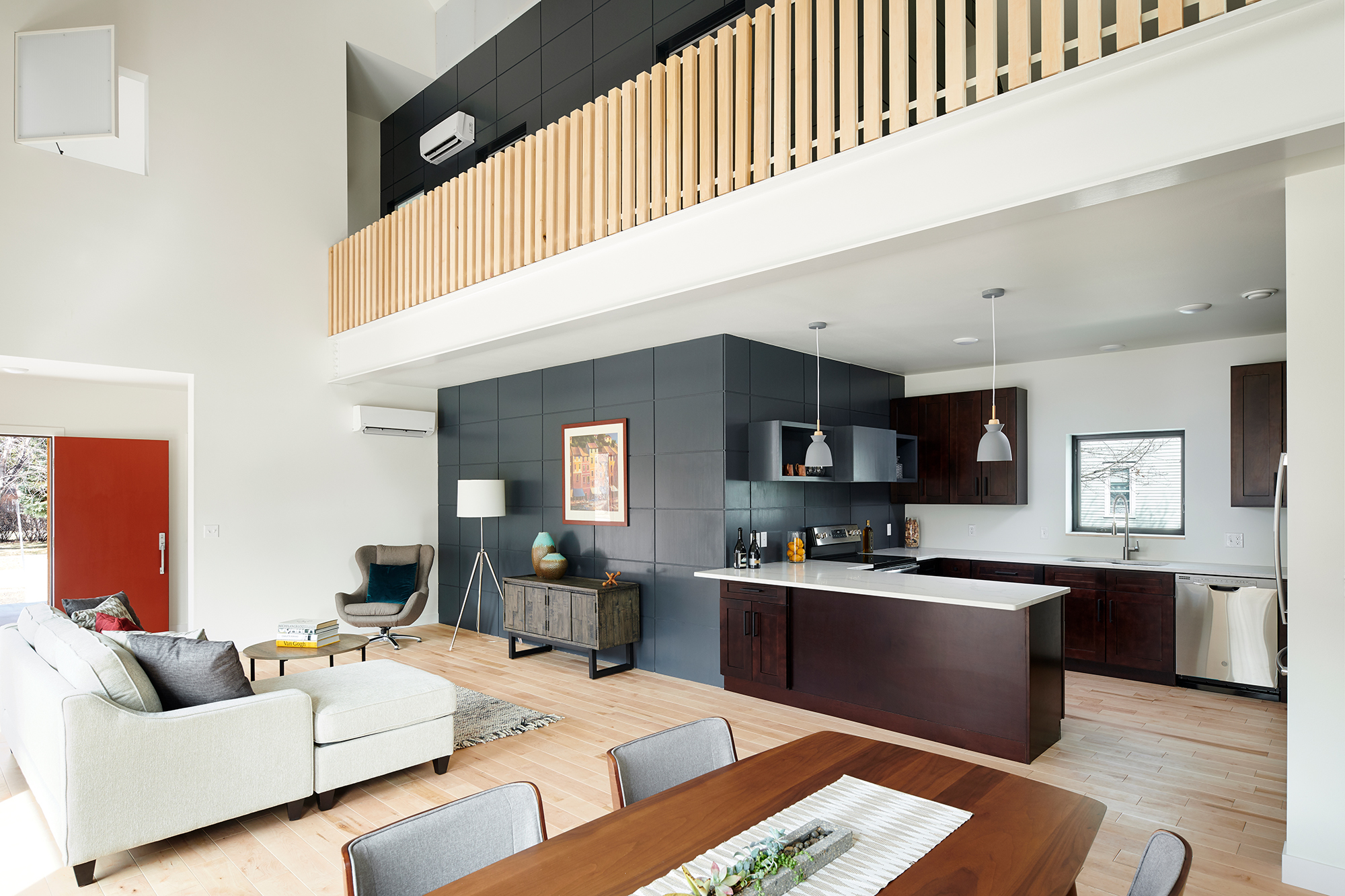 A double-height living and dining room and connected kitchen serve as the core of the house.