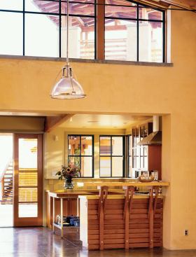 Salvaged cedar slats add a graphic element in the kitchen and bathroom. All of the beams in the house came from a dismantled military building.