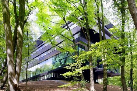 Rehabilitation Centre Groot Klimmendaal  Arnhem  The golden-brown anodized fa&ccedil;ade of the Groot Klimmendaal rehab center blends into the surrounding forest. Light wells bring daylight into the heart of the 98-foot-wide structure.