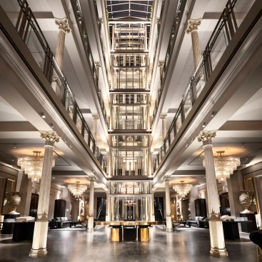 LED uplights at the elevator and columns accentuate RH New York's atrium space. Variable white floodlights are deployed within the interior of the elevator shaft.