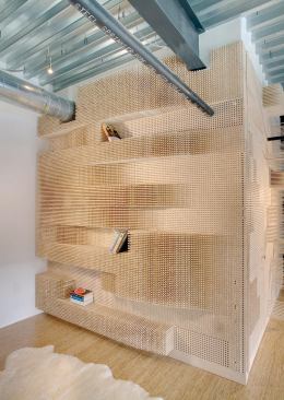 The Peg Wall Bookcase uses thousands of wood dowels to form an undulating, three-dimensional surface.