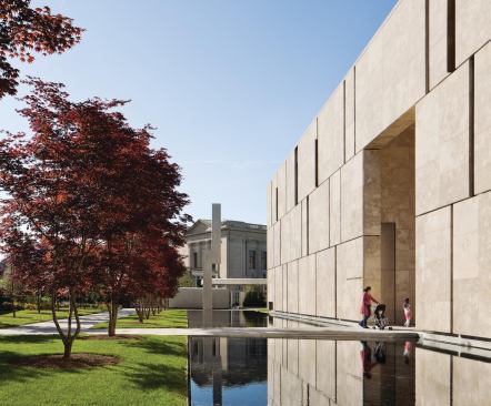 A series of gardens and hard- and soft-scaped areas surround the museum. Visitors cross a reflecting pool as they enter the museum. 